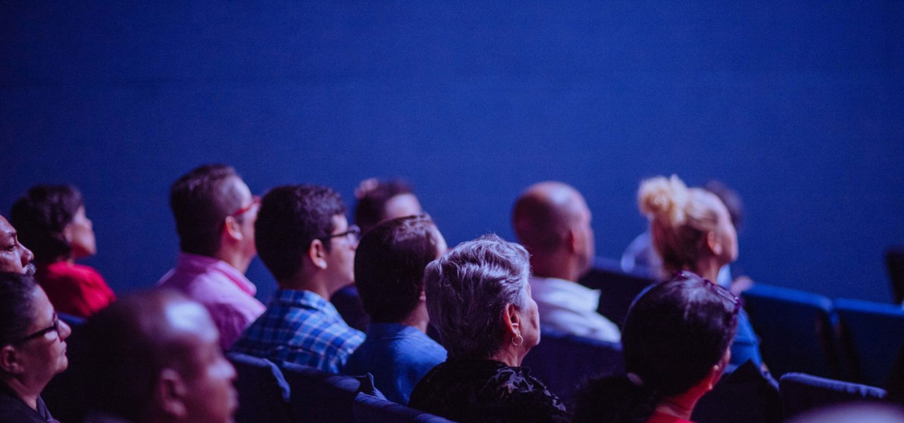 Audience in a cinema watching a film; blue lighting