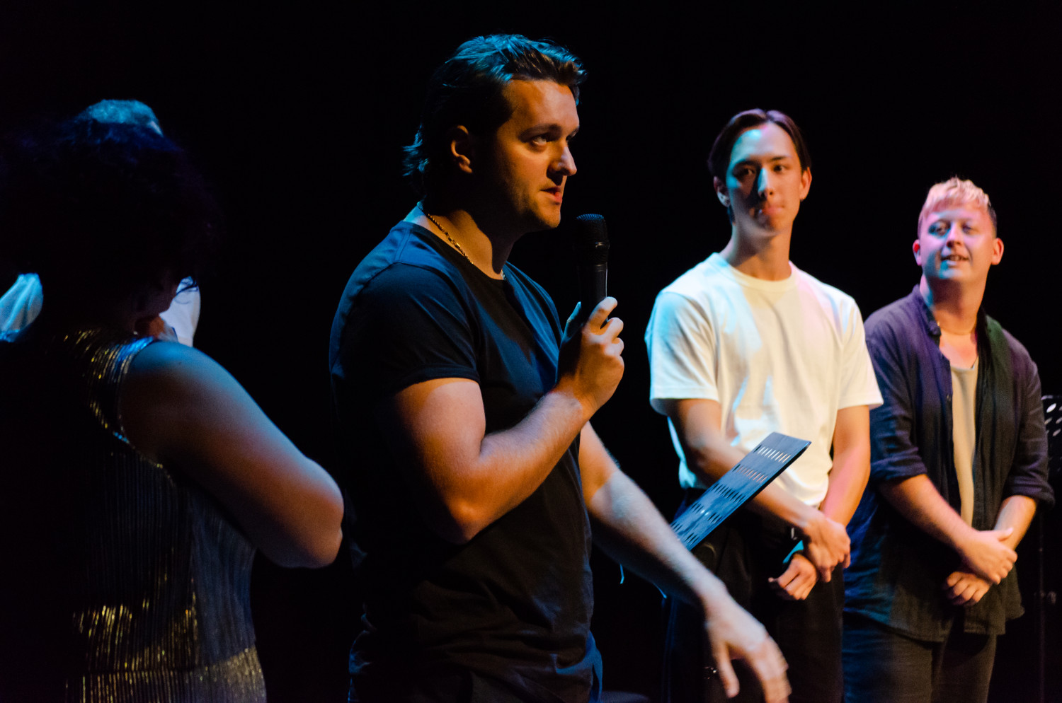 Callum speaking on stage, with actors in the background