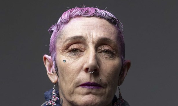 Headshot of Rissa Belle dressed in a pink jacket, denim shirt and a dark blue scarf