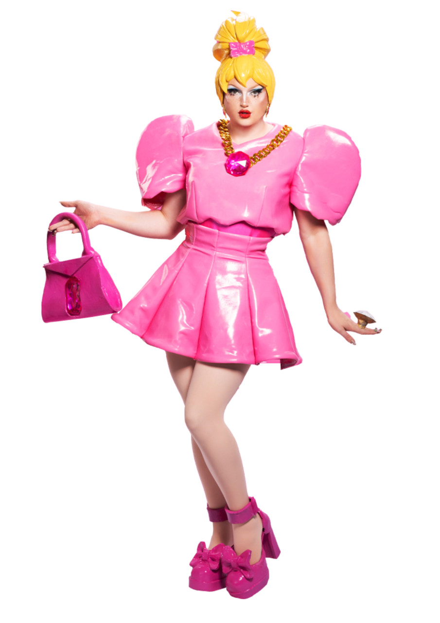 Lazy Susan dressed in pink vinyl holding a pink handbag and wearing a yellow wig