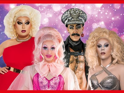 Drag queens (and king) on stage in front of mauve lighting with star-like light points