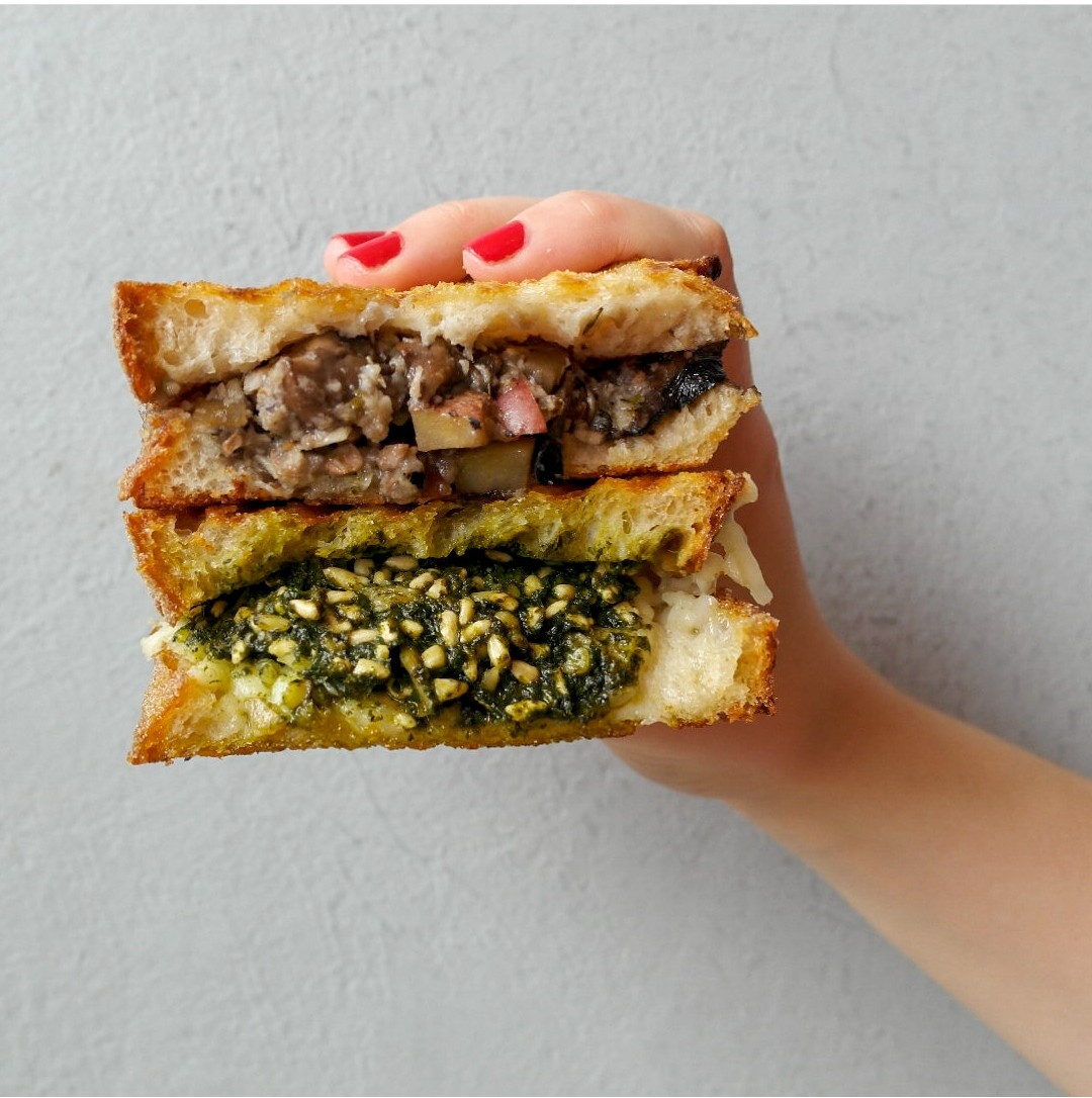 A hand holding a half-eaten toastie