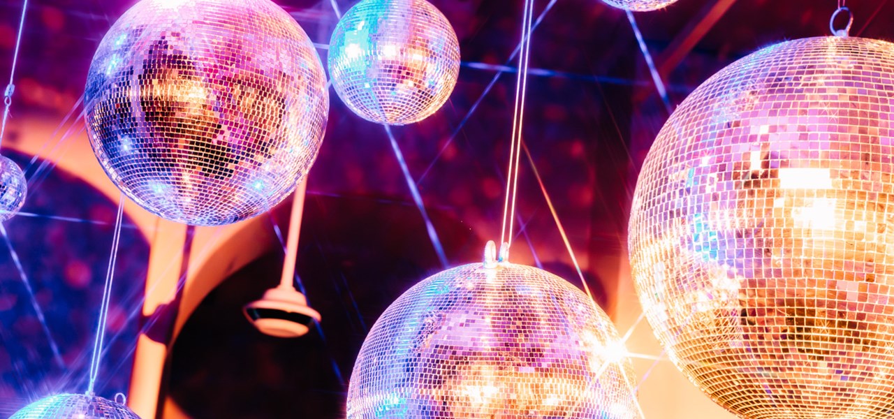 A bunch of disco balls with mauve-tinged lighting