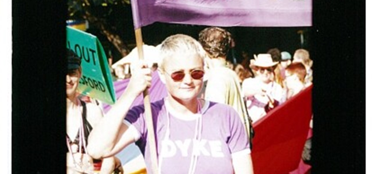 Pride March 2000 image: woman wearing a mauve t-shirt with "Dyke" printed on it