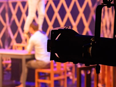 Phone held in a supporting bracket photographing a man sitting at a table - the man is out of focus