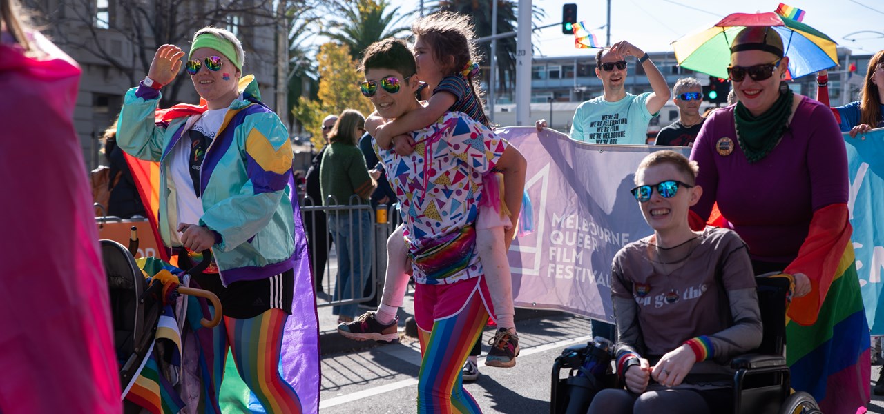 Photos of colourfully dressed people marching, one in a wheelchair
