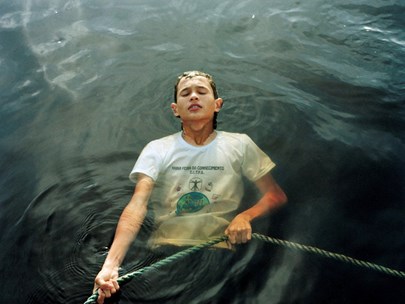 A person is gripping on to a rope while they are submerged in water.