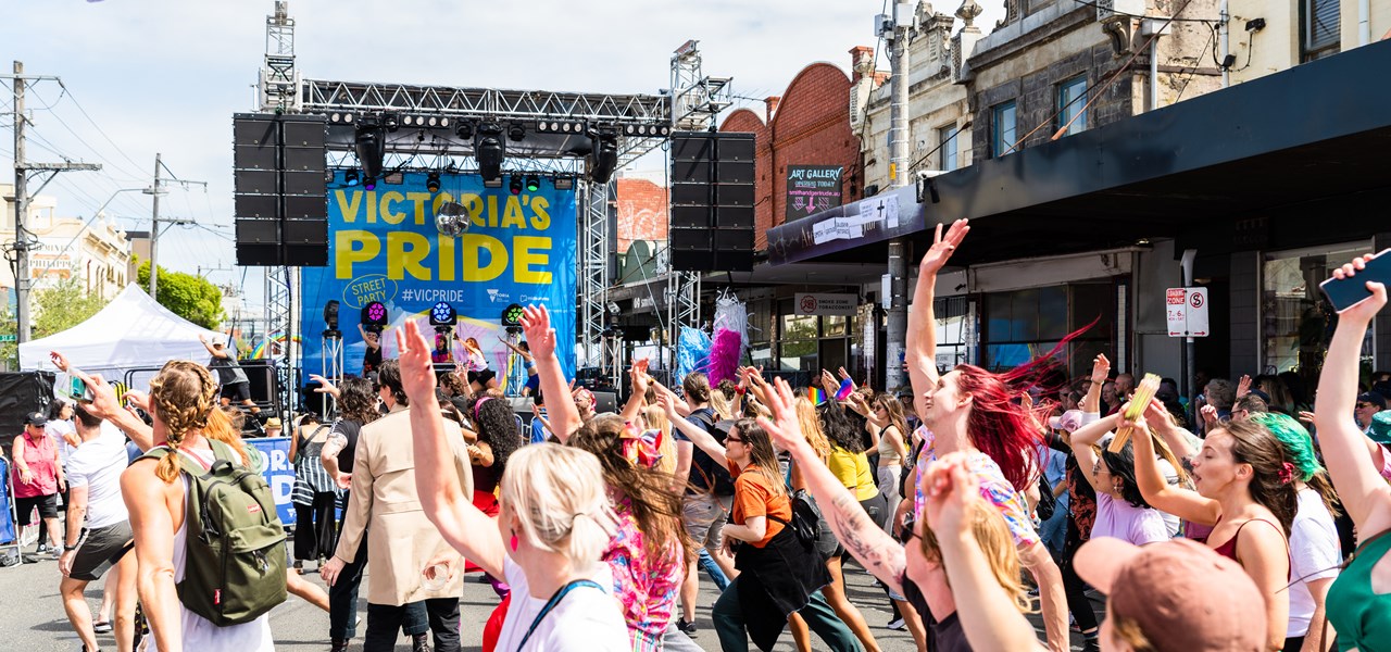 The crowd dancing with their hands in the air in front of the Victoria Pride Street in Party 2023