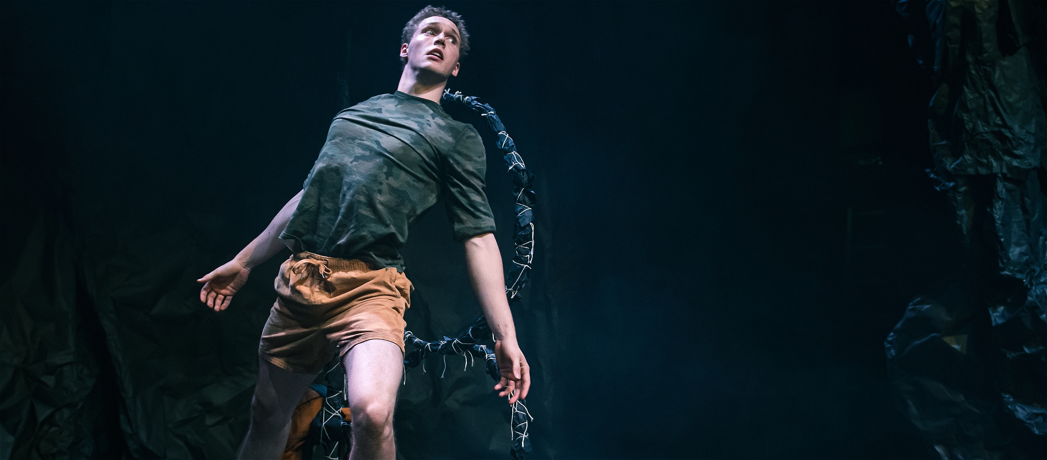 A man jumping through a hoop, looking scared.