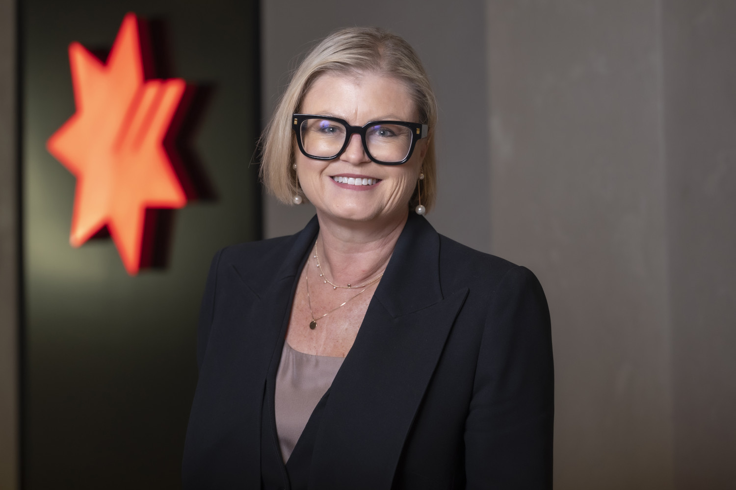 Headshot of Rachel Slade dressed in black, smiling with a NAB logo behind them
