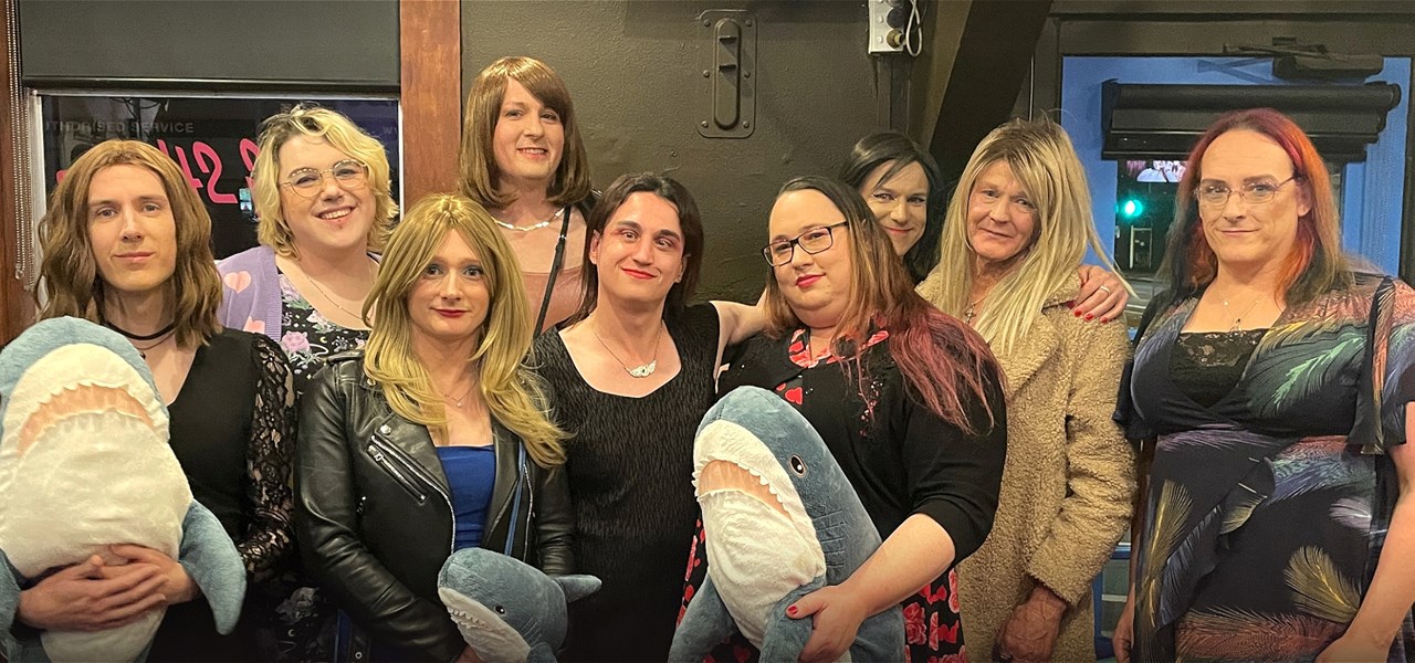 A group of nine event goers. All are transfemme or genderfluid.