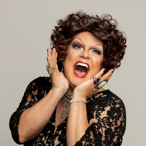 Headshot of Dolly Diamond who seems to be screaming while holding her head between her hands