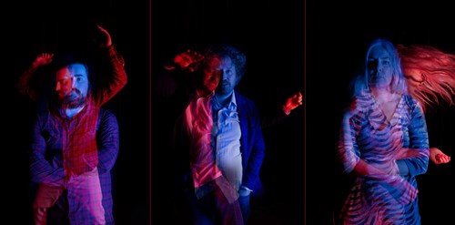 Three people against a black background, doubly-exposed to suggest movement
