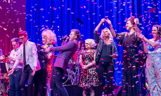 People on stage taking bows. Glitter descending from the roof