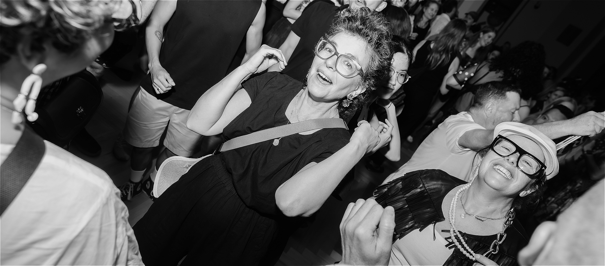 Black and White image of people on the dancefloor at the event having fun