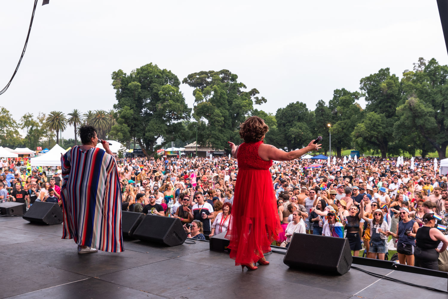 Two people on stage at Midsumma Carnival (one is Dolly Diamond), large crowd in background