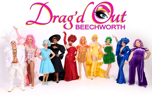 A line of colourful and glamorous drag kings and queens below a sign Dragd Out Beechworth