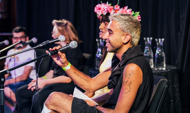 Happy looking people on the stage in front of microphones