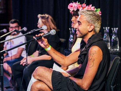 Happy looking people on the stage in front of microphones