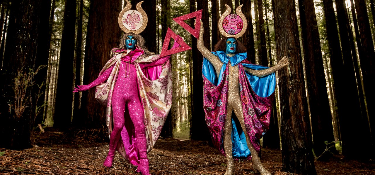 The Huxleys in glorious pink, gold and blue outfits in a forest setting