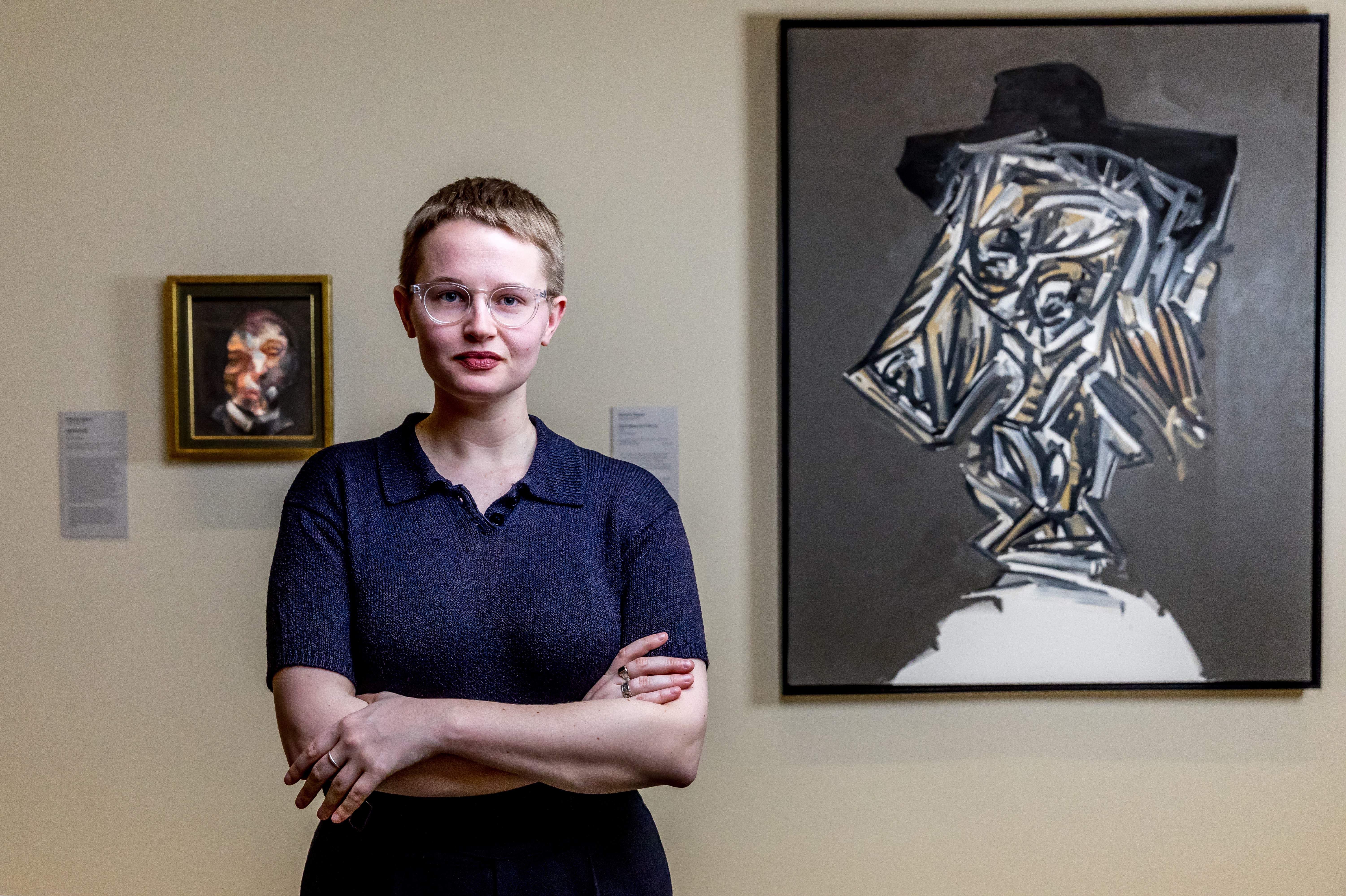 Meg Slater posing in front of art works