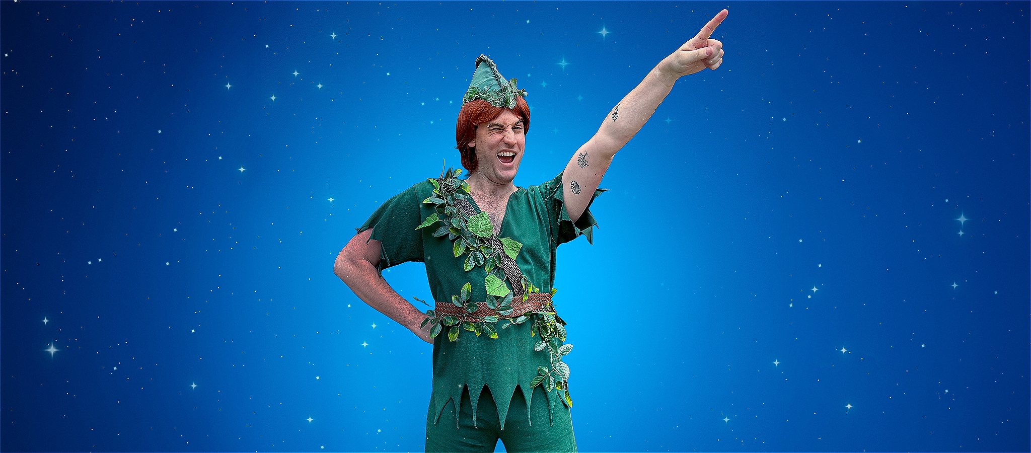 A young Peter Pan dressed in all green against a blue background
