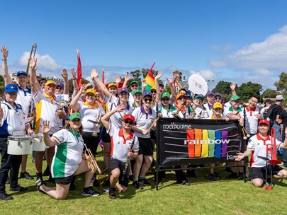 Rainbow Band members grouped behid their banner on the lawn at Midsumma Carnival