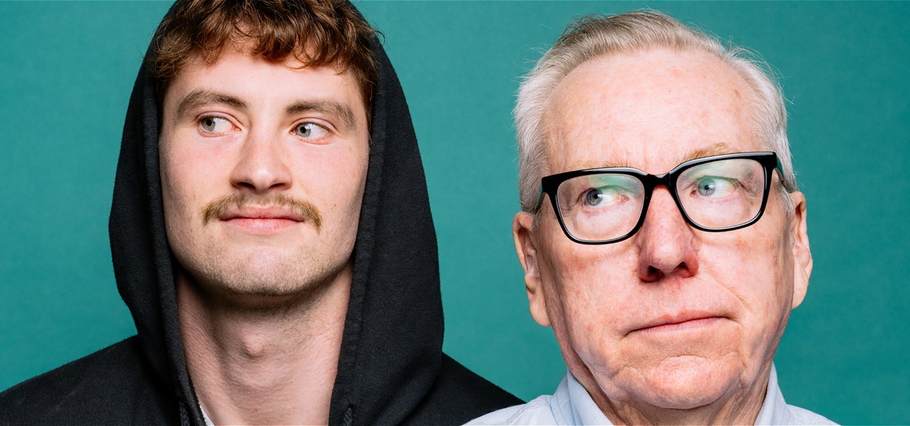 A young man dressed in a black hoodie and an old man wearing a shirt and glasses