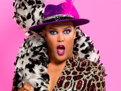 A person with pink lipstick, pink eyeshadow and a bright pink hat with a feather in it, site with their mouth open, and a black and white feather boa