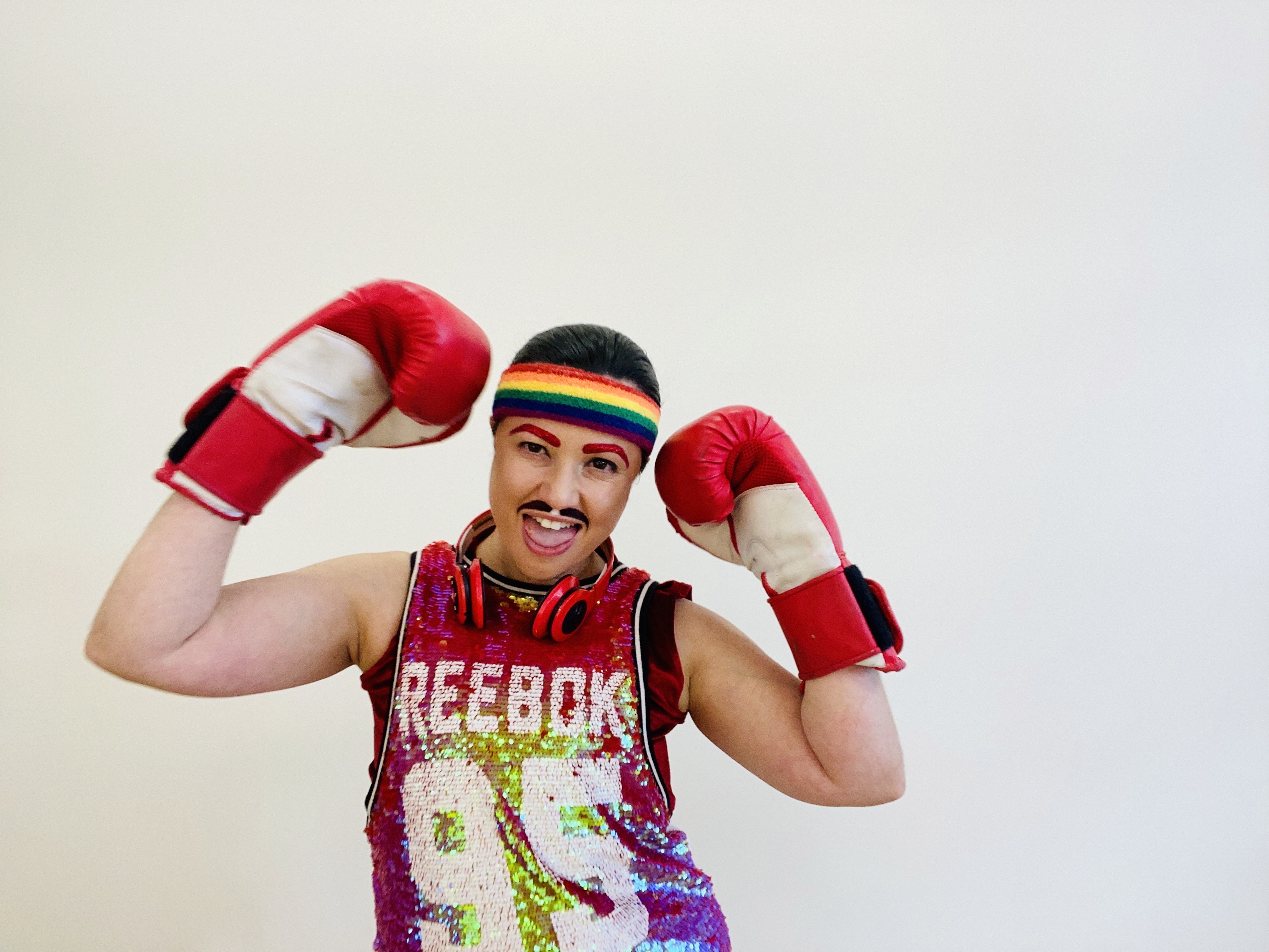 Donnie Piccolo wearing boxing gloves a rainbow beanie and a glittery REEBOK top