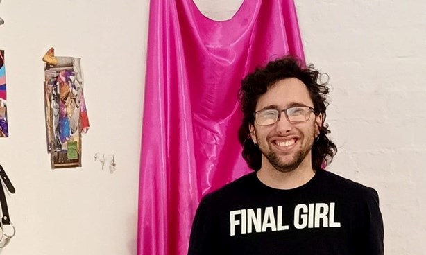 Head and torso of Sam Kariotis in a black t-shirt with text FINAL GIRL