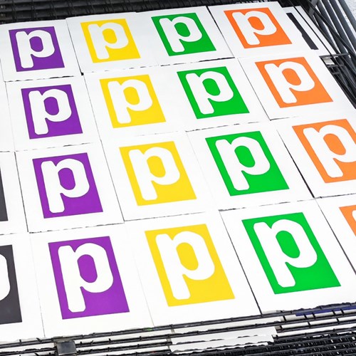 A book open at a page showing the letter P in the colours of the rainbow