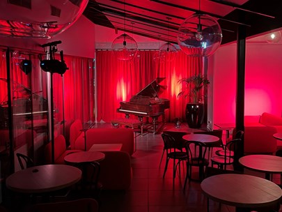 Image of the Clocktower piano bar, devoid of people, with subdued red lighting