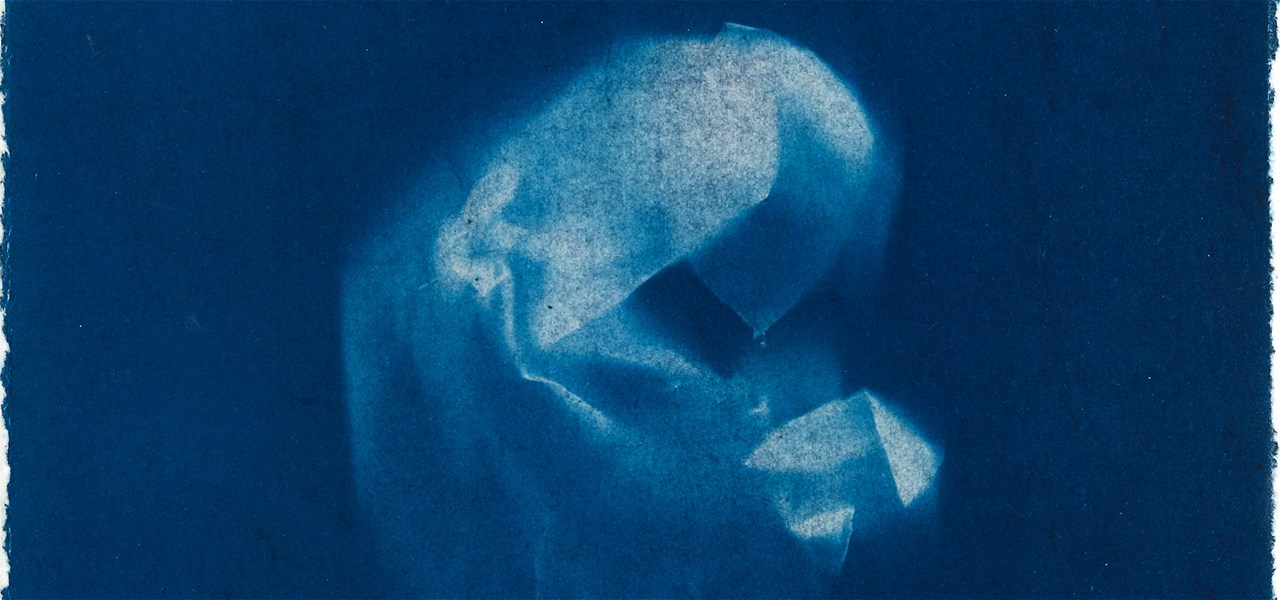 Light coloured crumpled fabric against a dark blue backdrop.