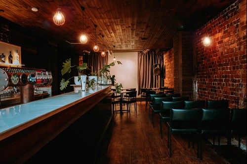A view down the side of a bar, looking towards a cabaret stage.