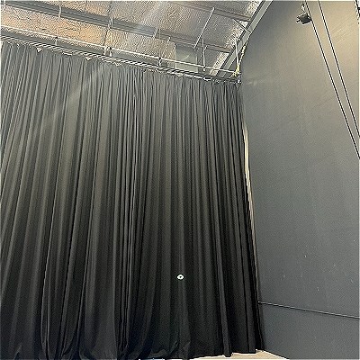 A black box theatre with floor to ceiling black drapes