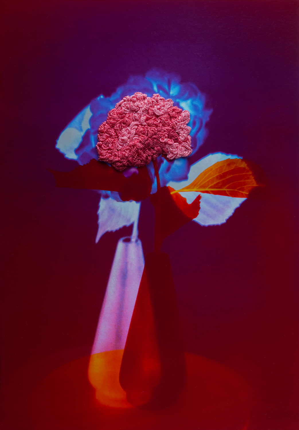 An artwork representing a vase of flowers. It appears to use some fabric.