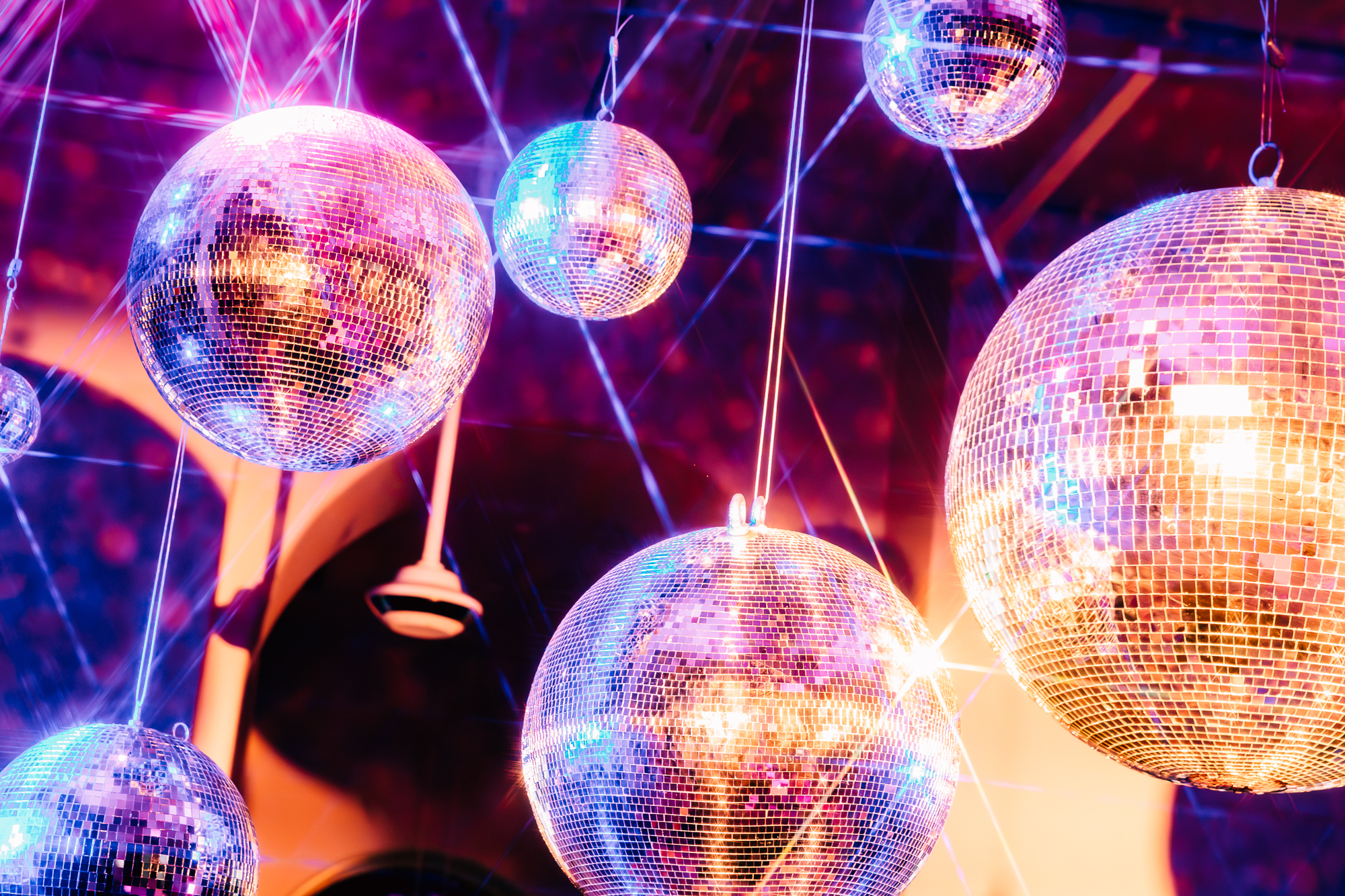 A bunch of disco balls with mauve-tinged lighting