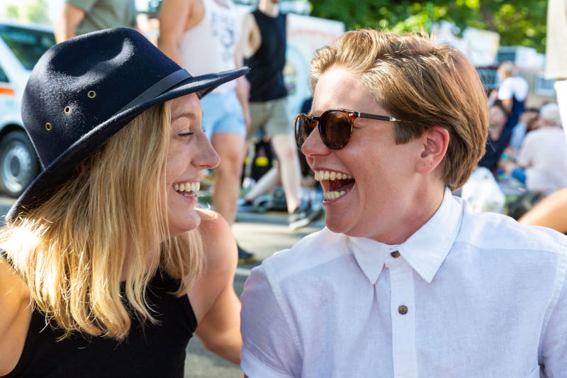 Two female-identifying people looking at each other while laughing loudly