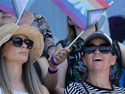 Audience at a match, with some audience members holding queer flags