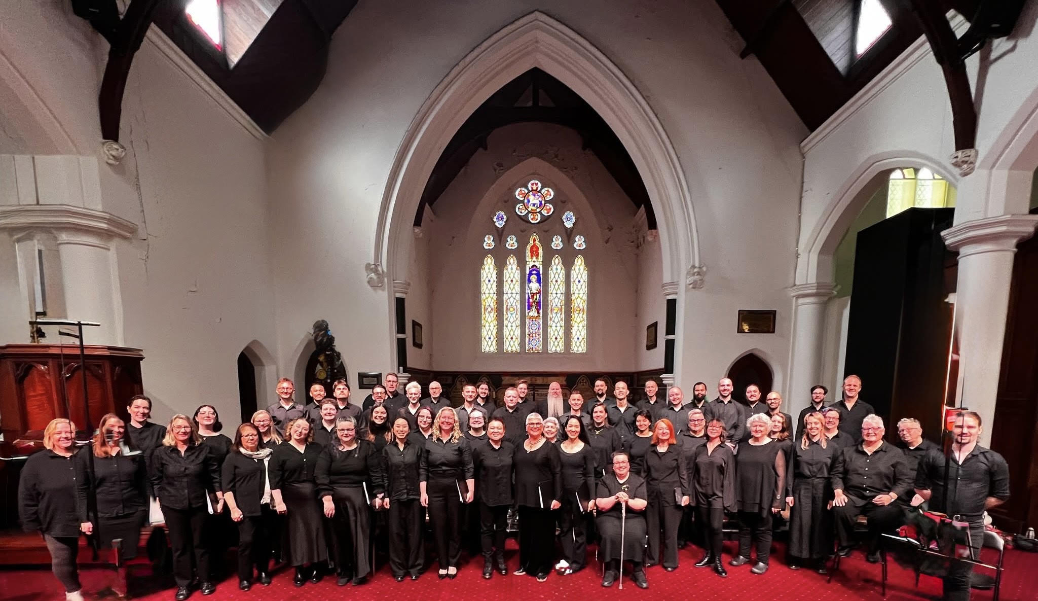 The chorus dressed in black inside a church