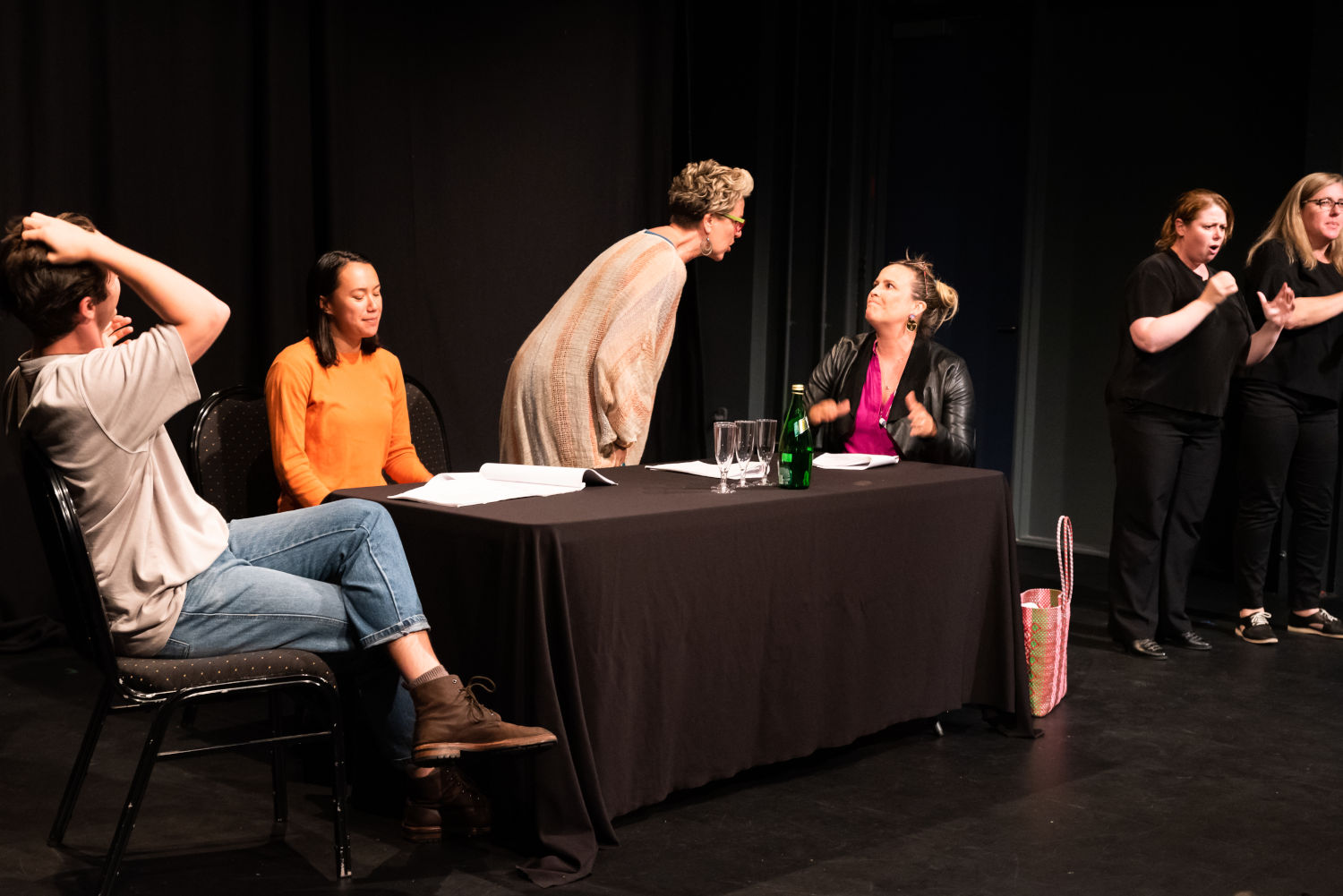 Four people on stage plus two Auslan interpreters. Older woman is talking 'excitedly' at a younger woman