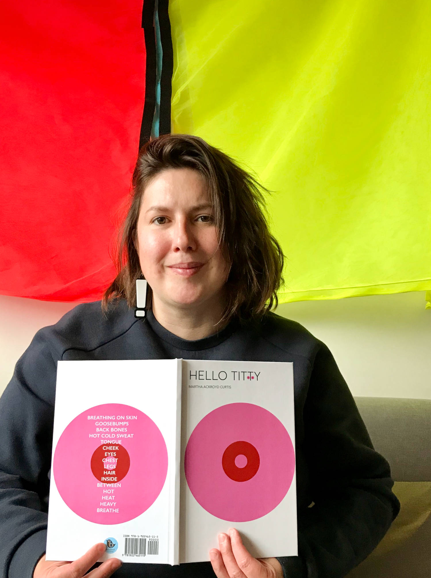 Portrait of Martha holding a copy of her book: 'Hello Titty'