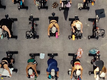 A group of people completing a spin class at the rooftop of the Pride Centre in 2023.