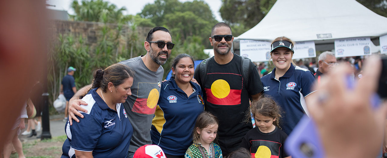 A group of Aboriginals posing for a photo - photographer and camera slightly visible