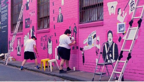 People paining (quality designs) on the outside of a building in Fitzroy