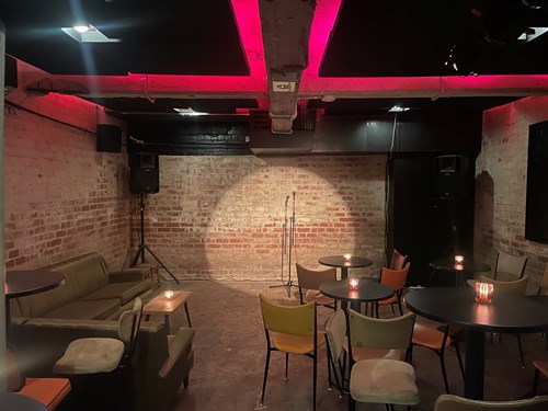 Cabaret seating facing a flat to floor stage and microphone