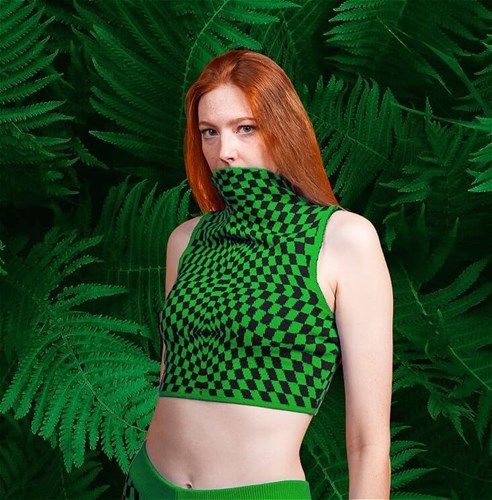 Person wearning bright green against a background of green ferns
