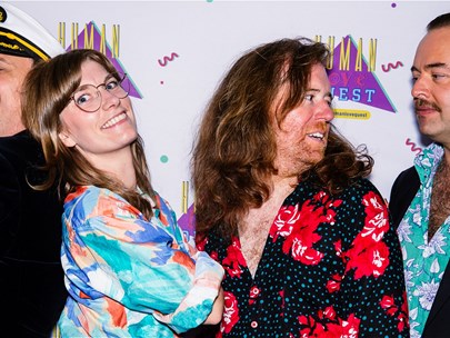 This is a photo of the 4 hosts of the show: Alex, Gretta, Xander and Conor standing in front of a HUMAN LOVE FEST banner.