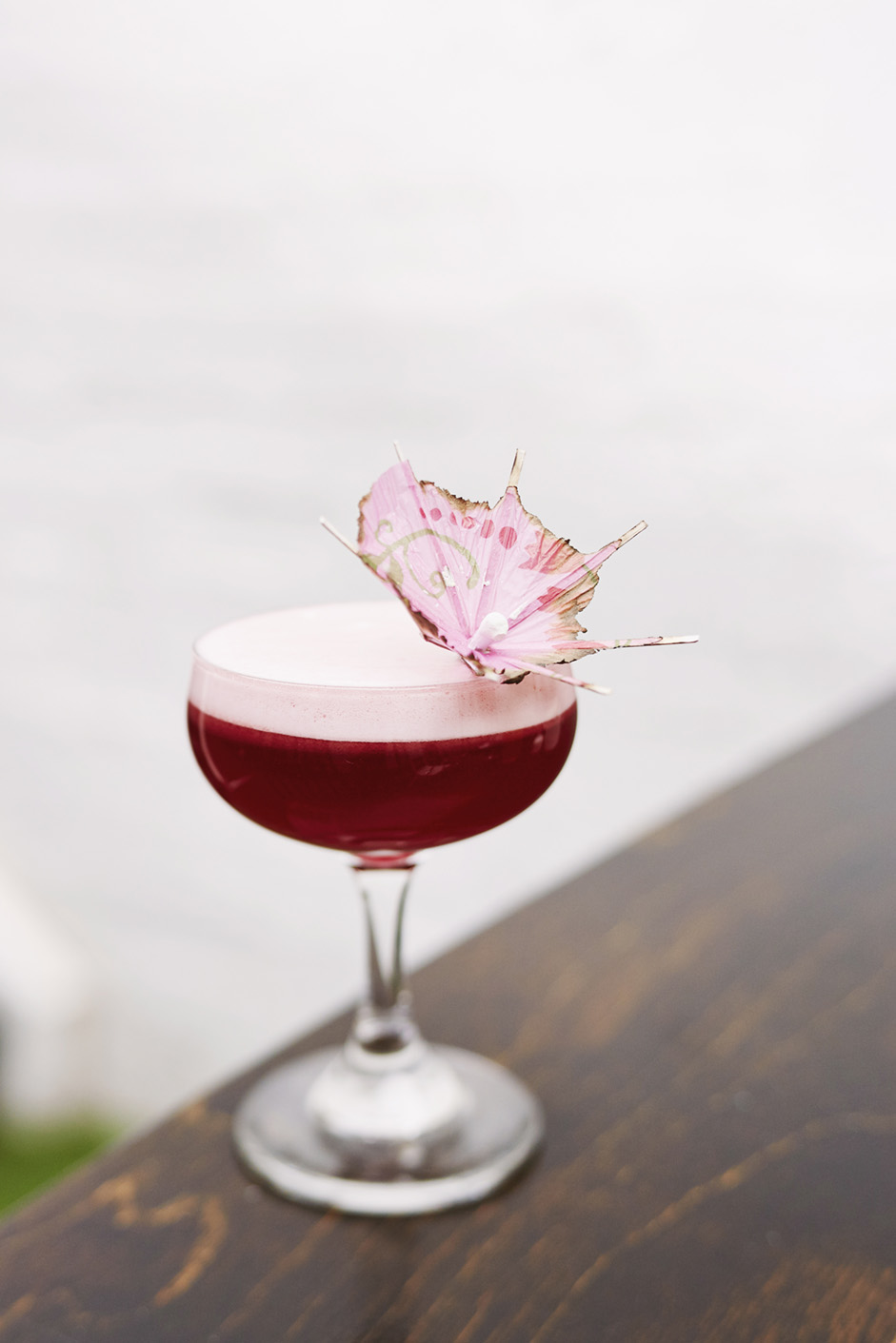 Glass of pink cocktail, with a pink umbrella in it